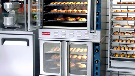 Flamaster FLM-COG-2 double deck gas convection oven loaded with bread in a bakery kitchen