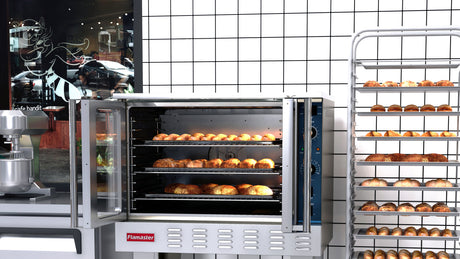 Flamaster single deck convection oven loaded with baked bread beside a full sheet pan rack